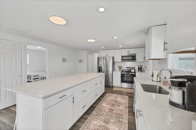 a large kitchen with stainless steel appliances lots of counter space and wooden floor