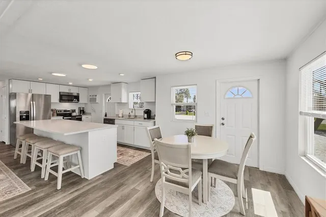 a dining room with livingroom view and wooden floor