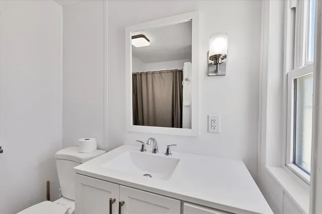 a bedroom with a bed and two windows