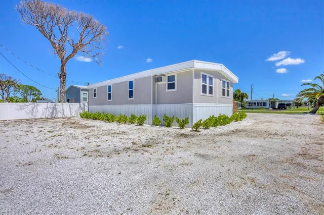 a front view of a house with a yard and potted plants