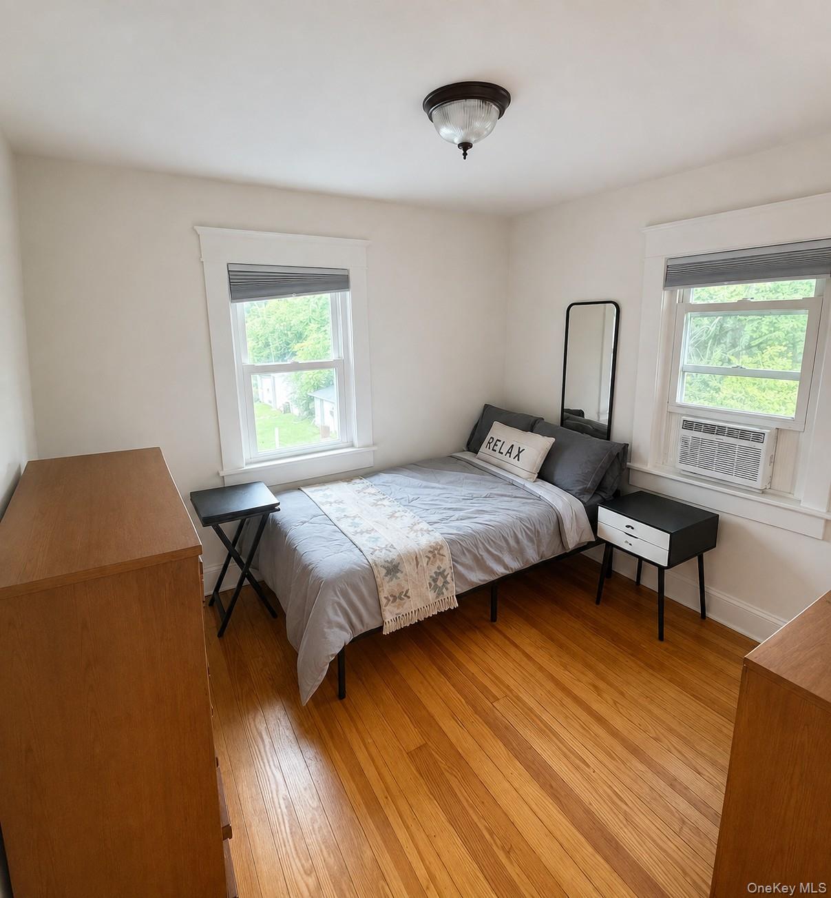 2374 Bruynswick Road Wallkill, NY 12589 - Photo 25 of 35 Hardwood flooring, two windows with window treatments, a flush mount ceiling light fixture, and white wall finishes
