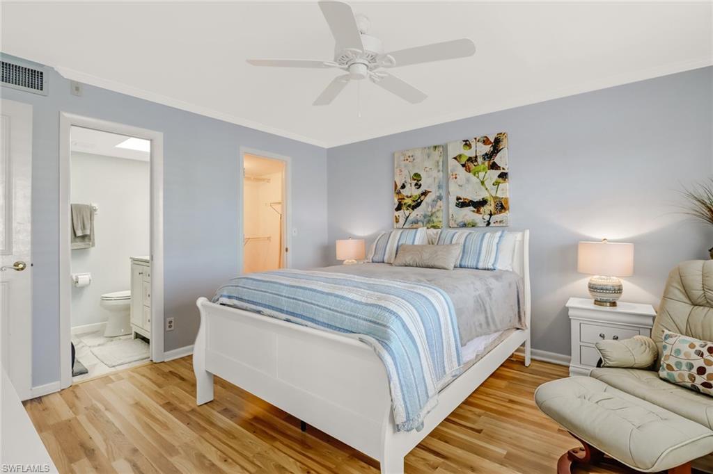 49 High Point Circle South, Unit 104 Naples, FL 34103 - Photo 16 of 30 a bedroom with a bed and wooden floor