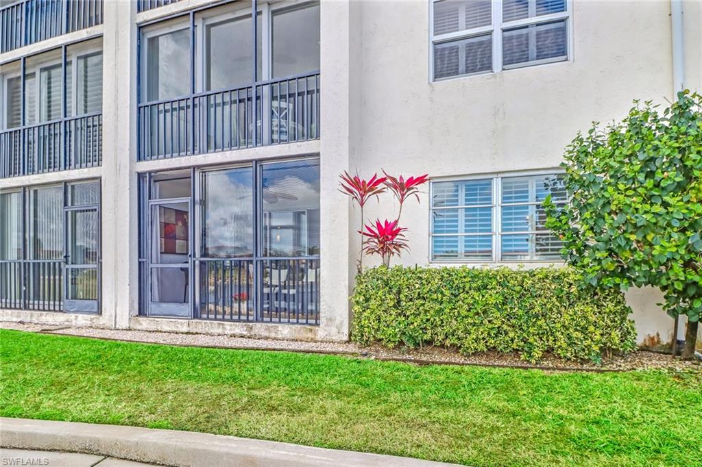 49 High Point Circle South, Unit 104 Naples, FL 34103 - Photo 24 of 30 a view of a house with a small yard and plants