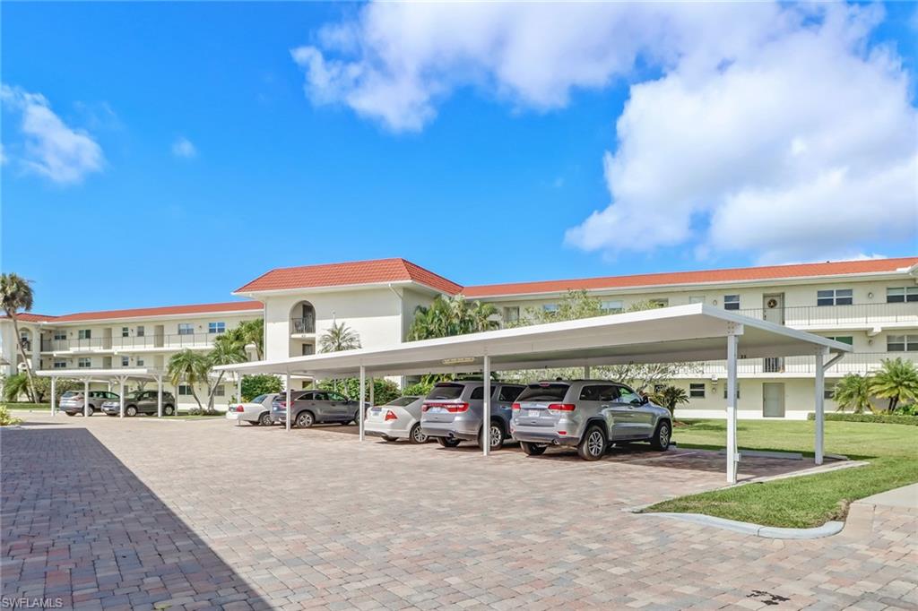 49 High Point Circle South, Unit 104 Naples, FL 34103 - Photo 4 of 30 a view of building with parking area