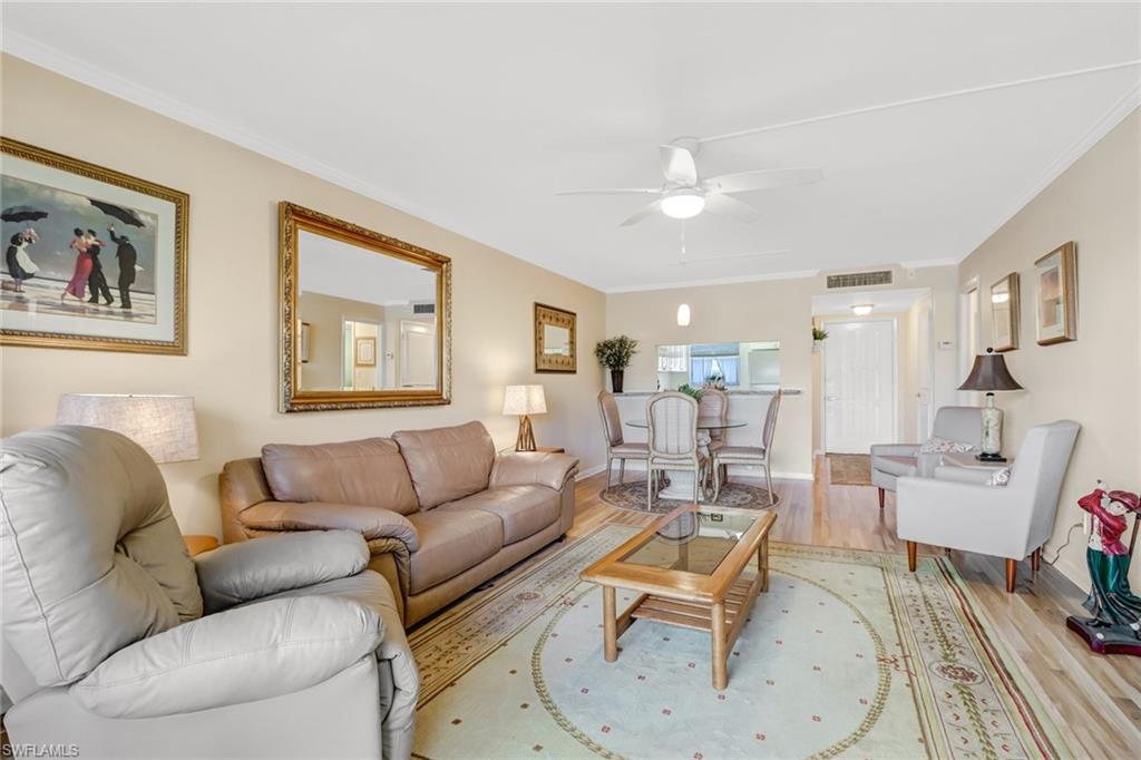49 High Point Circle South, Unit 104 Naples, FL 34103 - Photo 7 of 30 a living room with furniture and a table