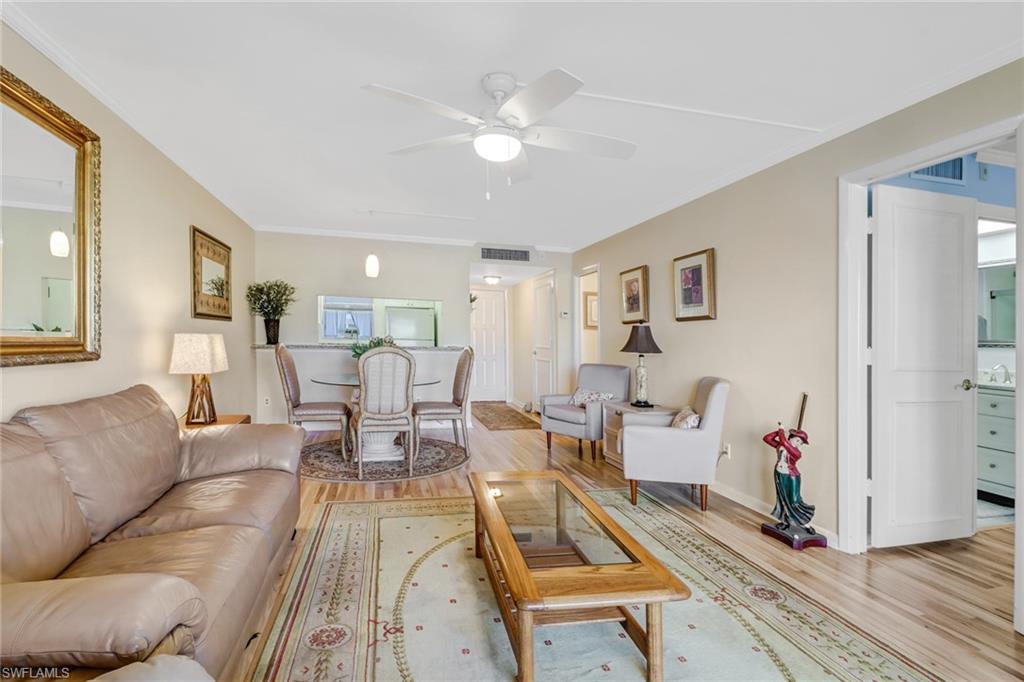49 High Point Circle South, Unit 104 Naples, FL 34103 - Photo 8 of 30 a living room with furniture and wooden floor