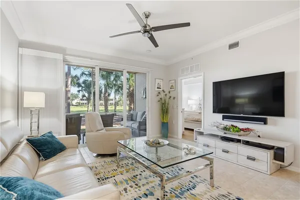 a living room with furniture a flat screen tv and a large window
