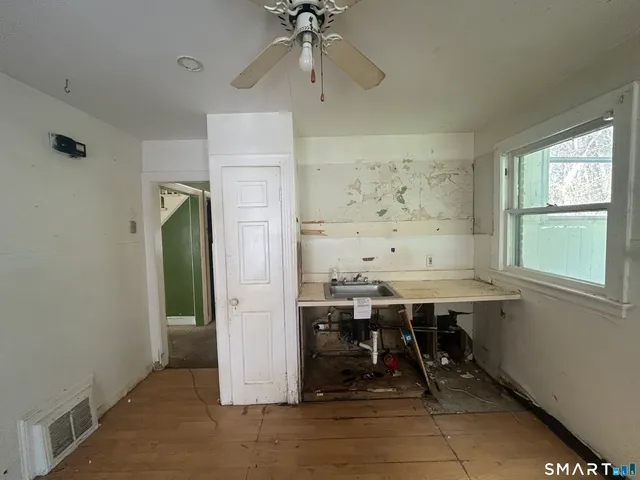 an empty room with a window and a fan
