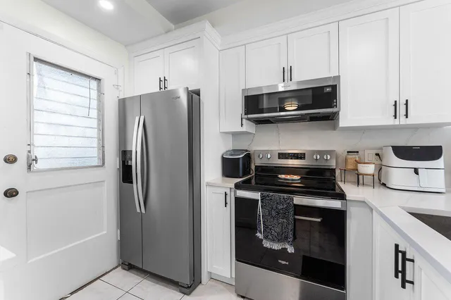 a kitchen with stainless steel appliances granite countertop a refrigerator stove and sink