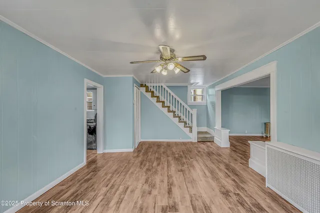 a view of entryway and hall with wooden floor