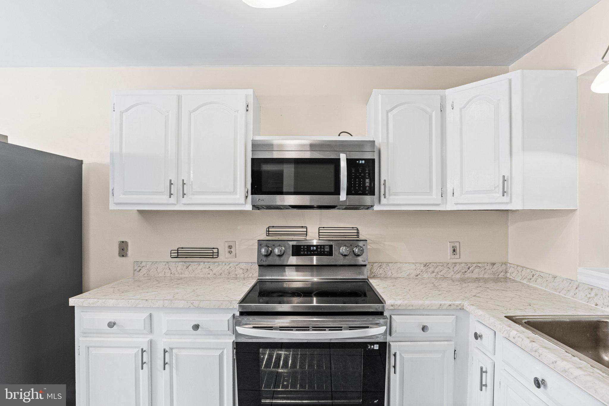 207 Crescent Drive Hershey, PA 17033 - Photo 14 of 42 a kitchen with stainless steel appliances granite countertop a stove a microwave and a white cabinets