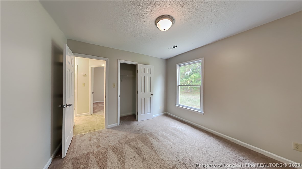 1112 Hoke Loop Road Fayetteville, NC 28314 - Photo 11 of 14 an empty room with windows and closet