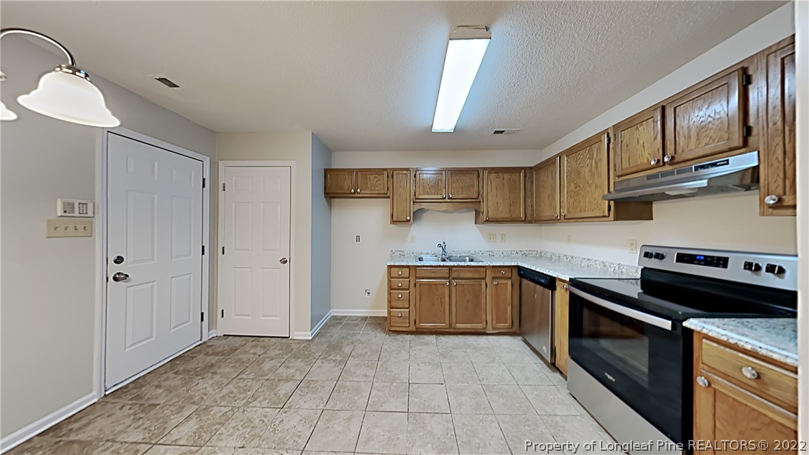 1112 Hoke Loop Road Fayetteville, NC 28314 - Photo 4 of 14 a kitchen with stainless steel appliances granite countertop a stove sink and cabinets