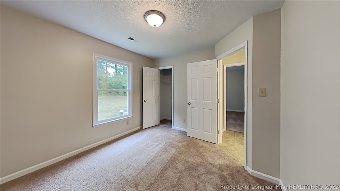 1112 Hoke Loop Road Fayetteville, NC 28314 - Photo 9 of 14 an empty room with windows and closet