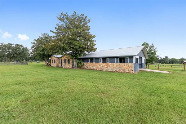 a view of a green field with wooden fence