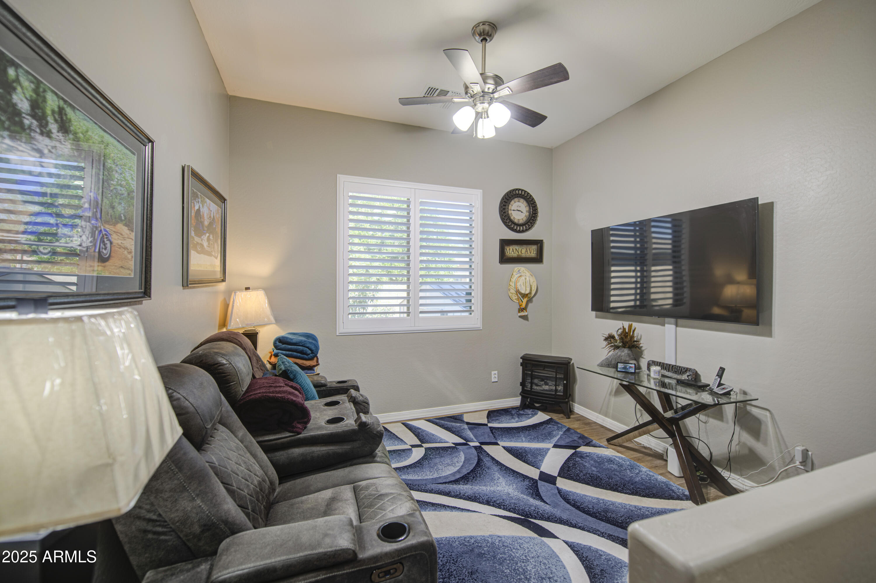 14304 West Coronado Road Goodyear, AZ 85395 - Photo 19 of 66 a living room with furniture a large window and a flat screen tv