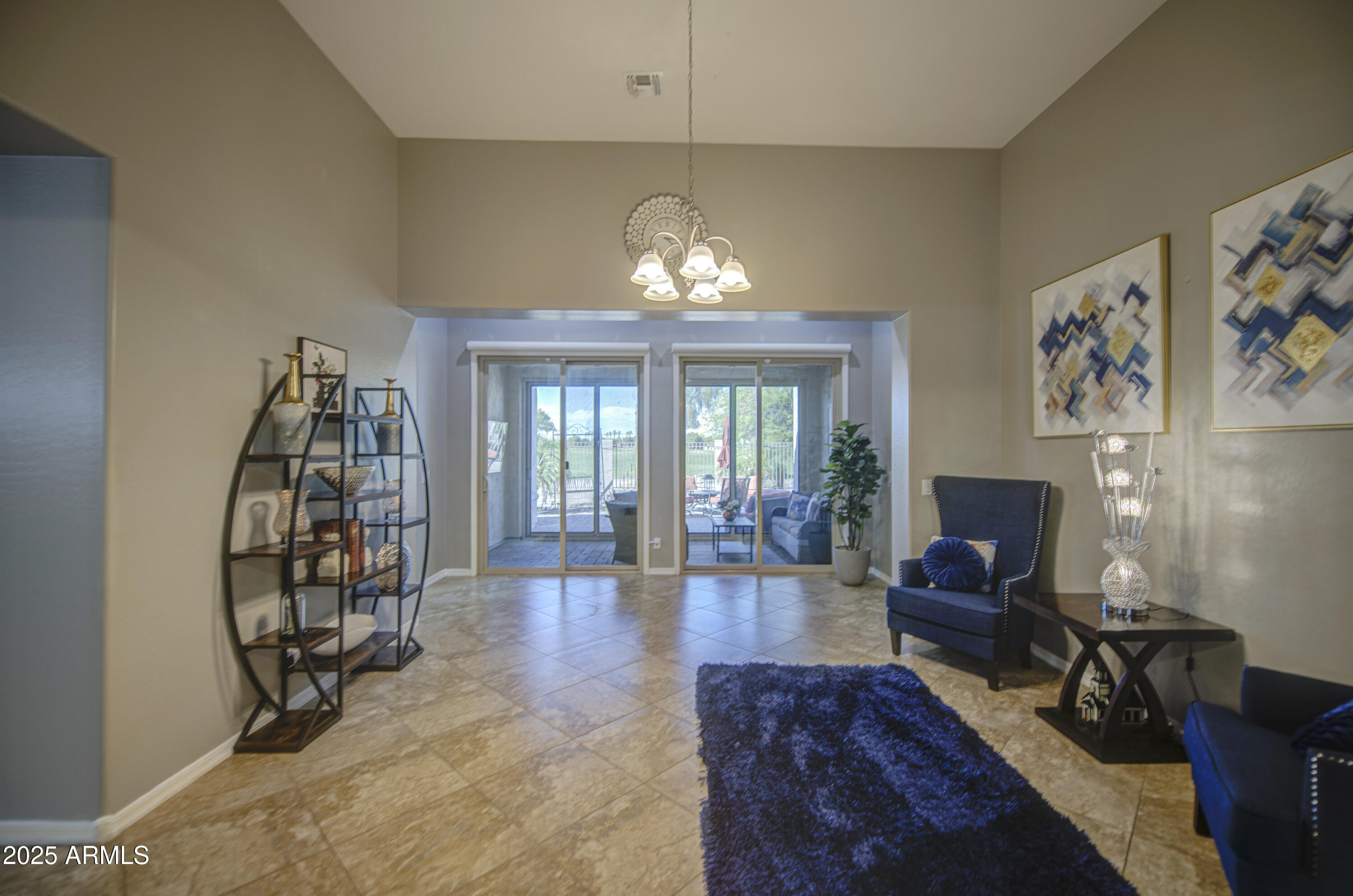 14304 West Coronado Road Goodyear, AZ 85395 - Photo 31 of 66 a view of a livingroom with furniture a flat screen tv and a chandelier