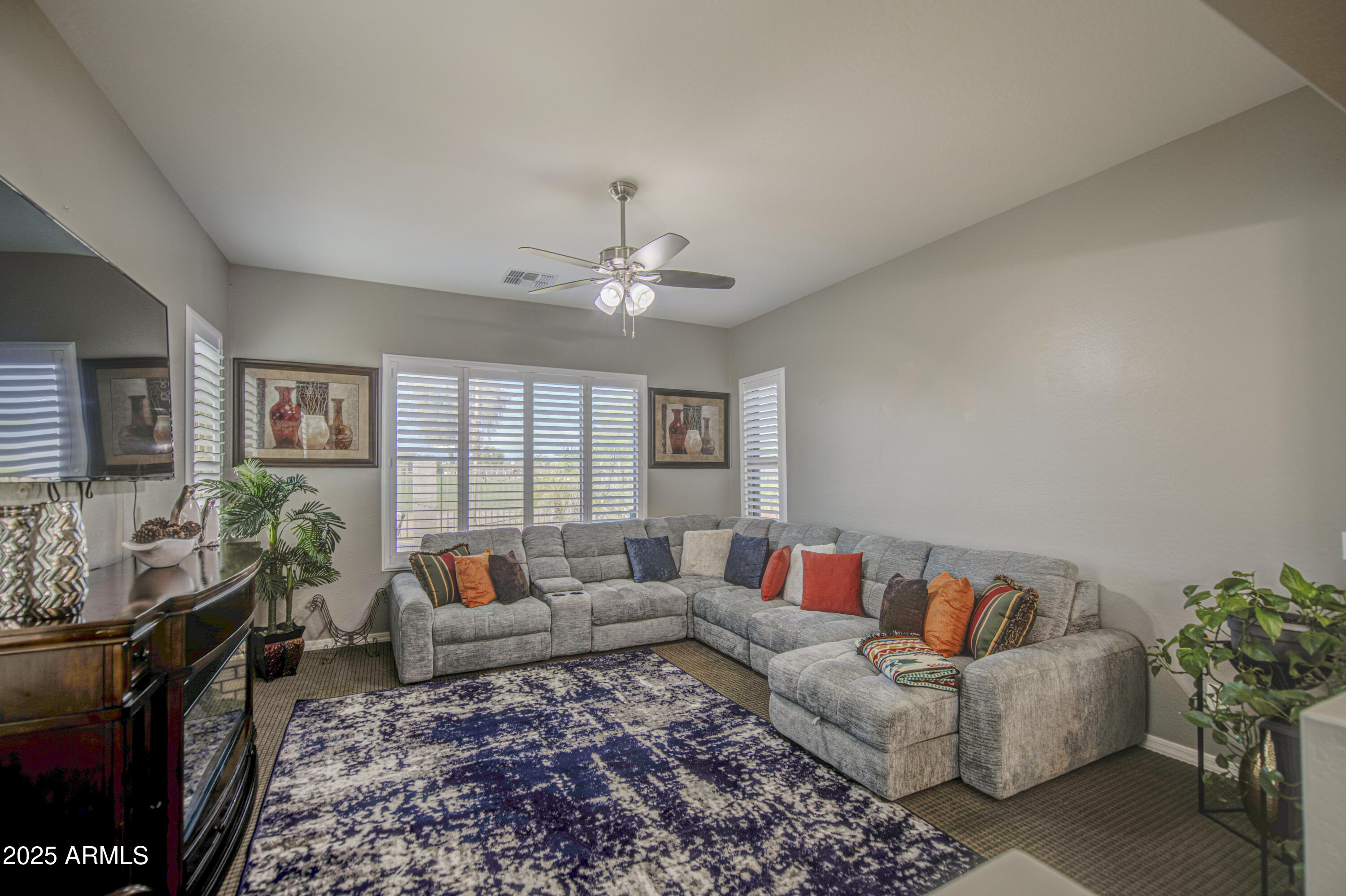 14304 West Coronado Road Goodyear, AZ 85395 - Photo 47 of 66 a living room with furniture and a flat screen tv