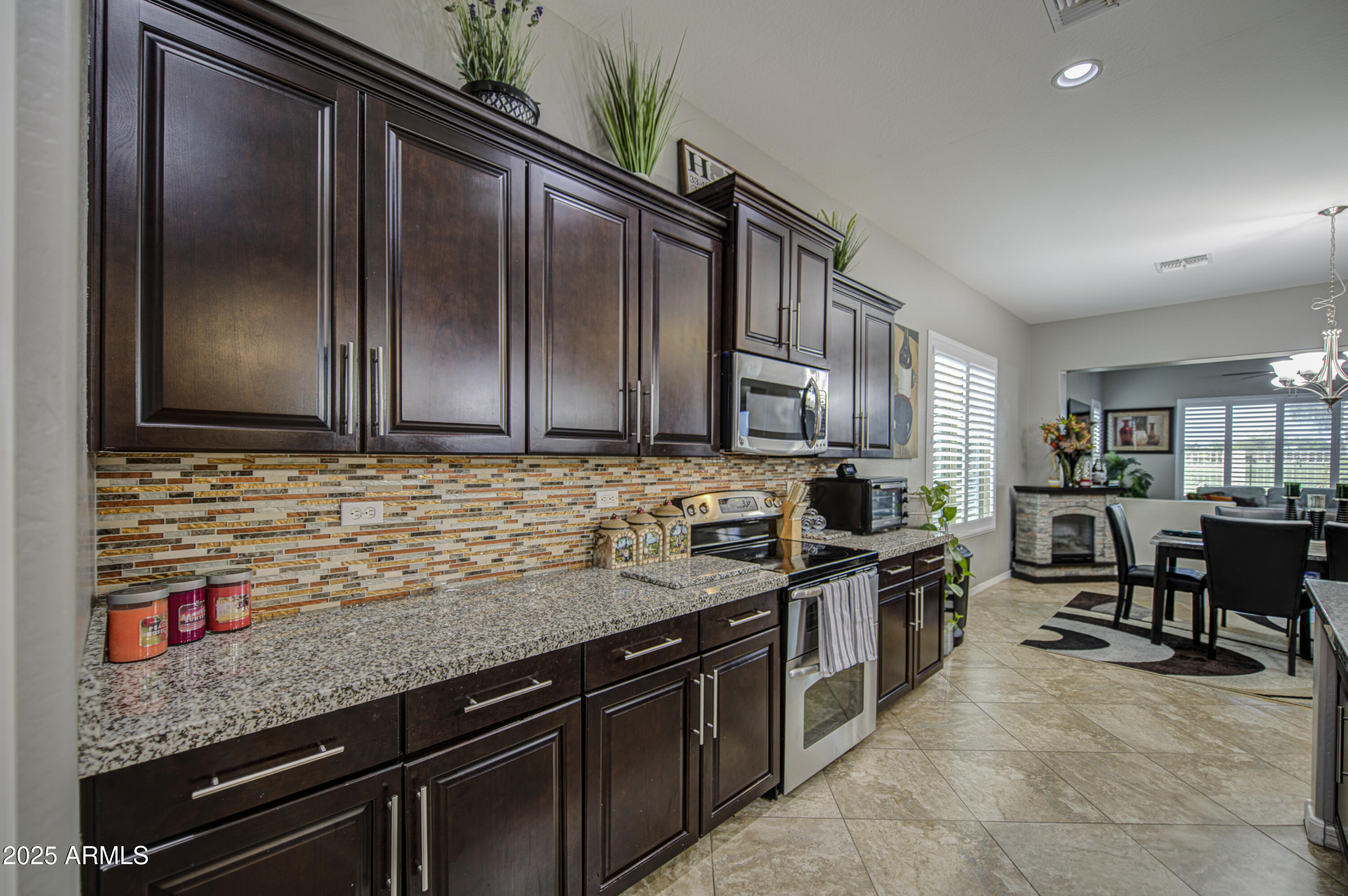 14304 West Coronado Road Goodyear, AZ 85395 - Photo 9 of 66 a kitchen with stainless steel appliances granite countertop a sink stove and cabinets