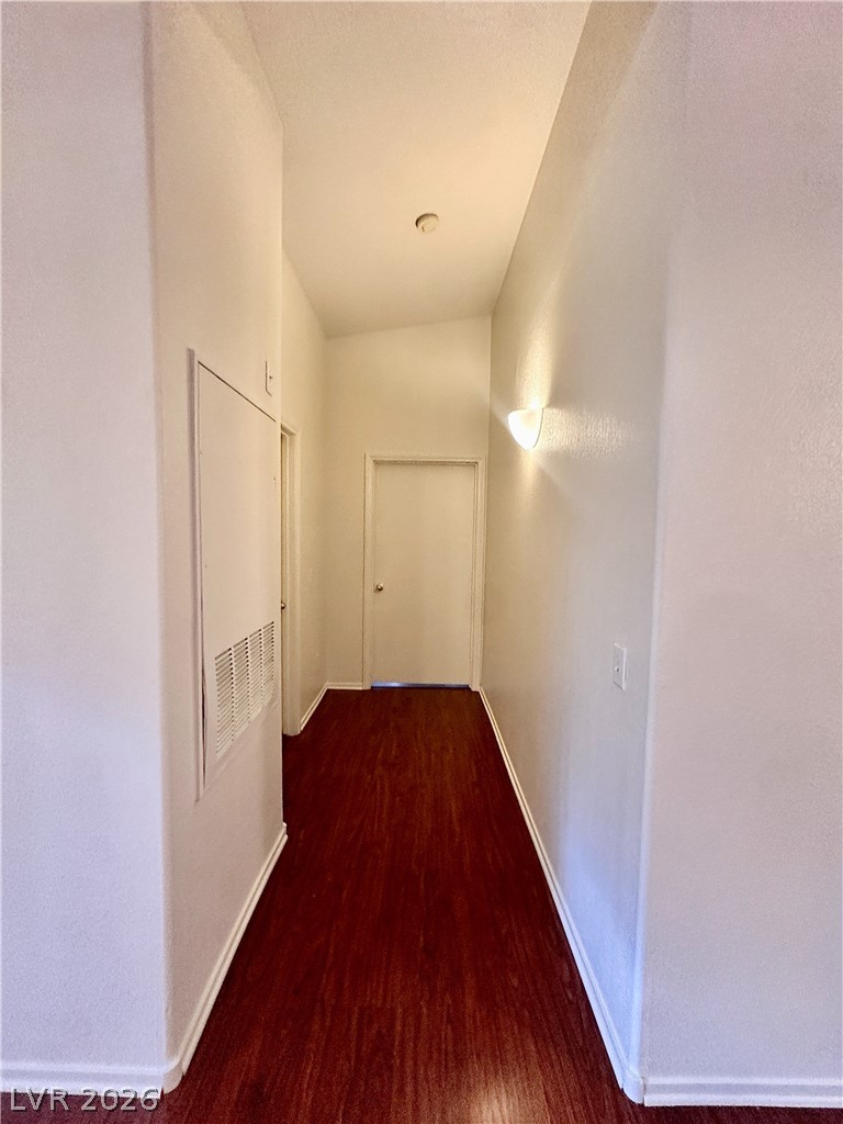 2053 Turquoise Ridge Street, Unit 202 Las Vegas, NV 89117 - Photo 6 of 18 Rich wood flooring contrasts with crisp white walls along this high-ceilinged hallway.