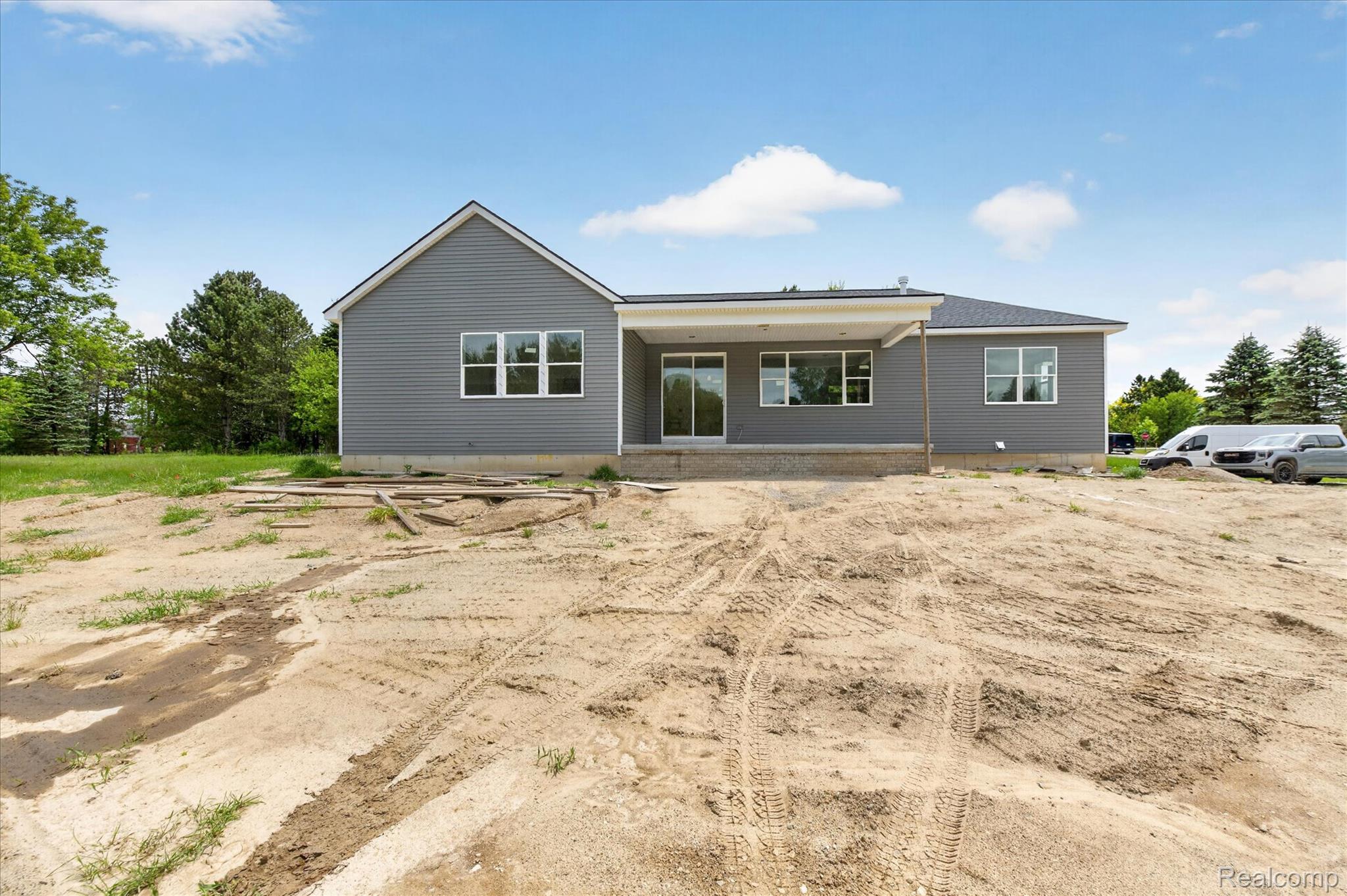 3297 Oak Grove Road Howell, MI 48855 - Photo 25 of 40 Backyard elevation with large windows bringing natural light into the home.