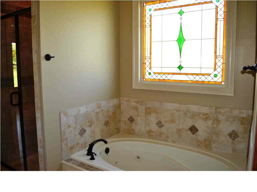 119 Burne Run Madison, MS 39110 - Photo 19 of 29 Nice stain glass accents the bathtub.