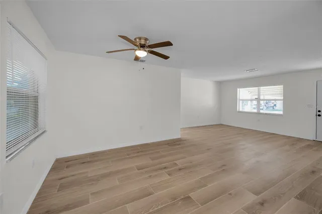 a view of empty room with wooden floor and window
