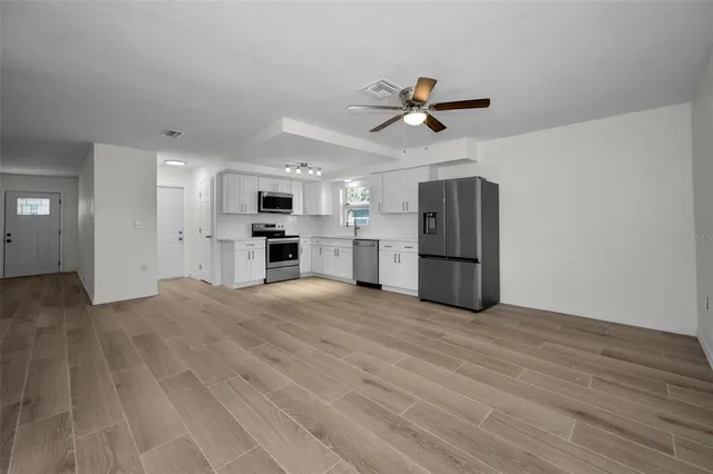 a view of empty room with wooden floor