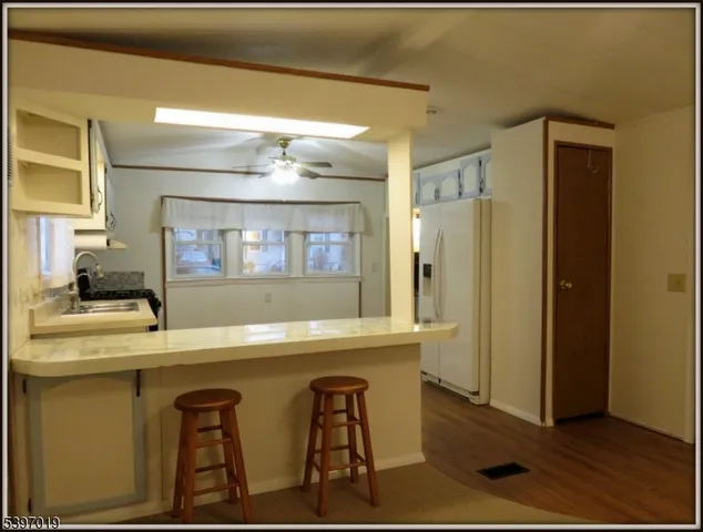 a dining hall with stainless steel appliances granite countertop a sink and a refrigerator