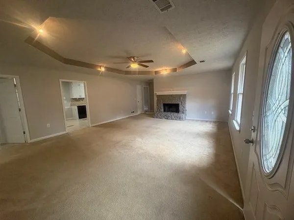 en empty room with windows and fireplace