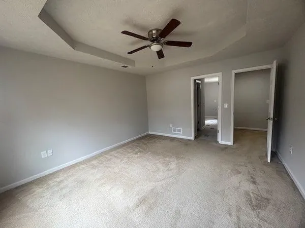 an empty room with a ceiling fan and window