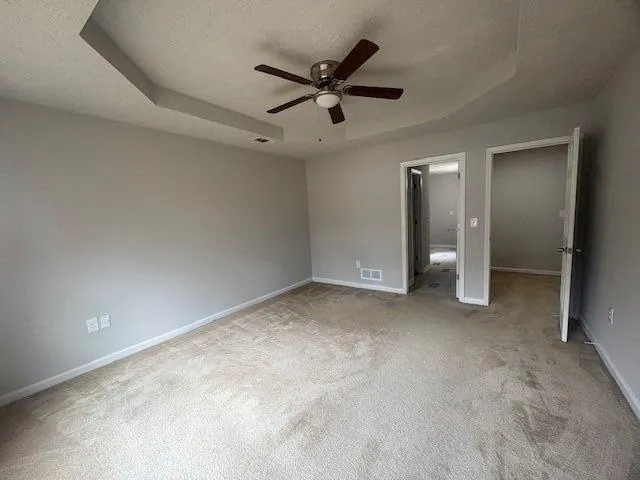 an empty room with a ceiling fan and window