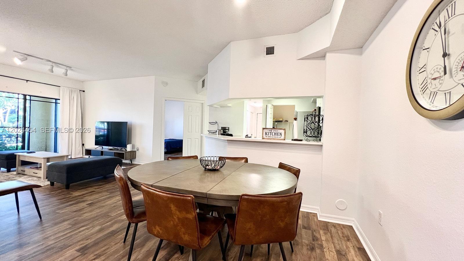 2727 Anzio Court, Unit 106 Palm Beach Gardens, FL 33410 - Photo 2 of 43 a view of a dining room with furniture and wooden floor