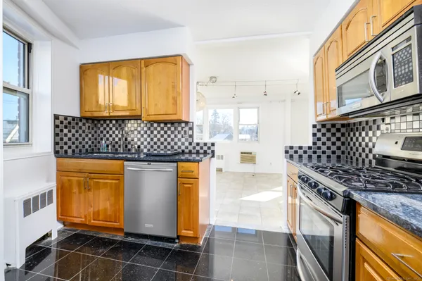 a kitchen with granite countertop a stove a sink and a cabinets