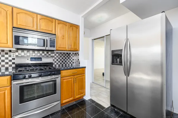a kitchen with stainless steel appliances granite countertop a sink stove and refrigerator