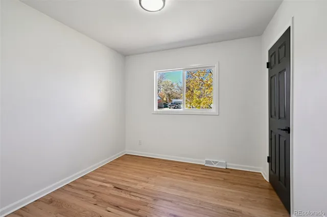 a view of empty room with wooden floor