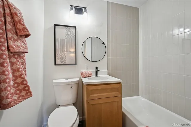 a bathroom with a toilet sink vanity and mirror