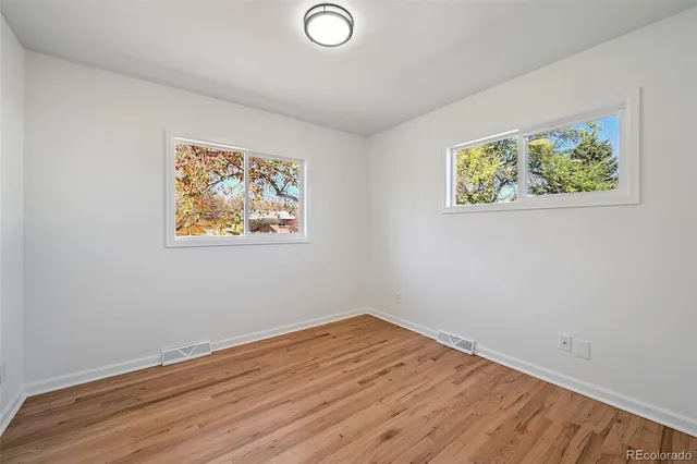 a view of empty room with wooden floor