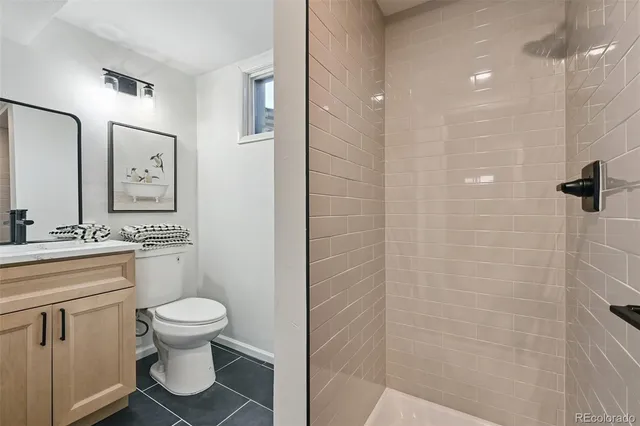 a bathroom with a toilet sink vanity and mirror