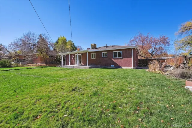 a view of a house with a big yard and large trees