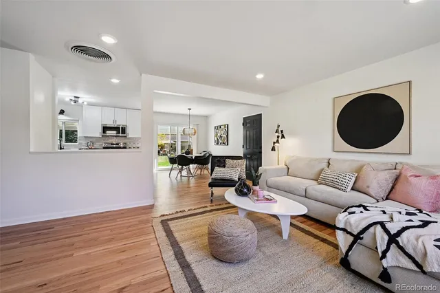 a living room with furniture and a wooden floor