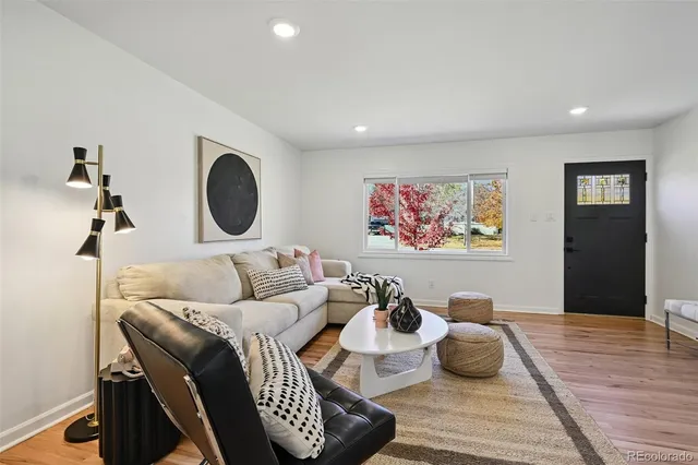 a living room with furniture and a wooden floor