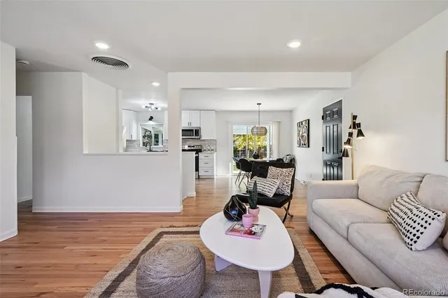 a living room with furniture and wooden floor
