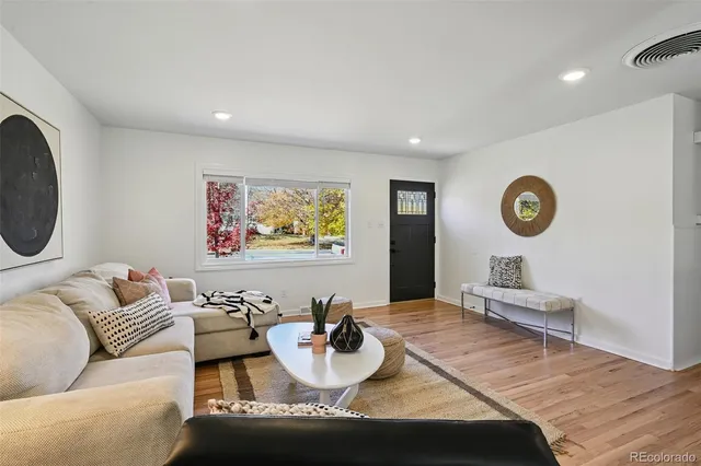 a living room with furniture and a wooden floor