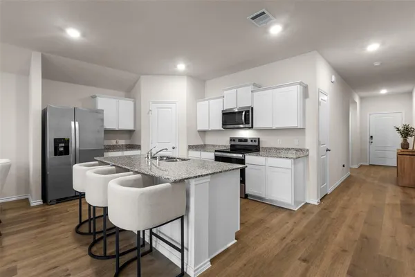 a kitchen with refrigerator cabinets and wooden floor