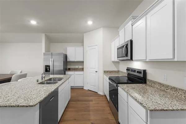 a kitchen with stainless steel appliances granite countertop a sink stove and refrigerator