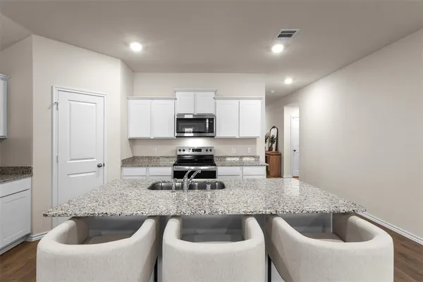 a kitchen with a white table and chairs