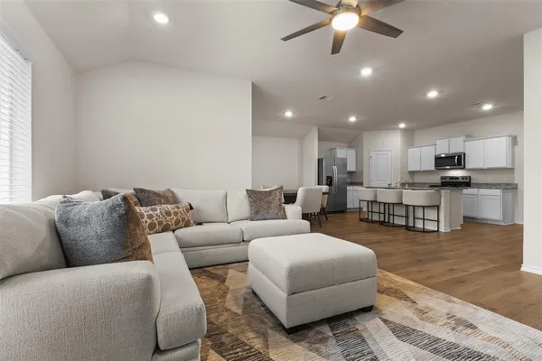 a living room with furniture and kitchen view