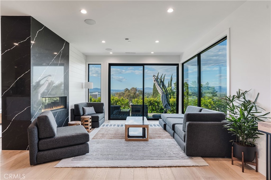 a living room with furniture plant and large windows