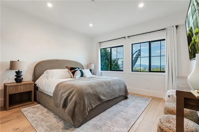 a spacious bedroom with a bed and wooden floor